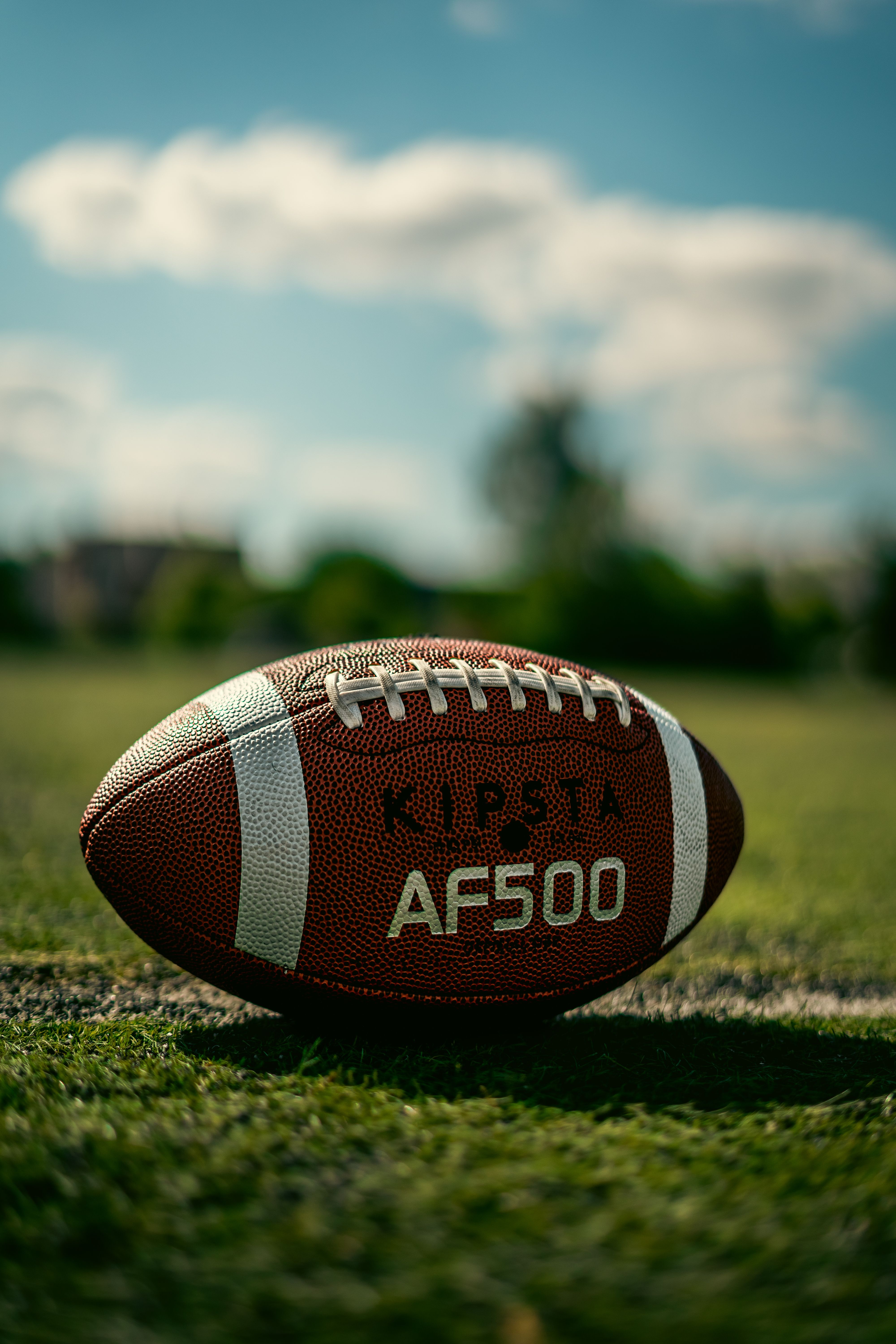 Football on a field beneath a blue sky